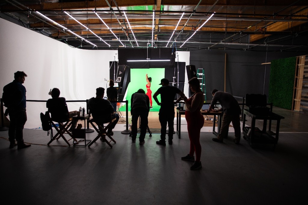 A production crew filming a green-screen shoot on set